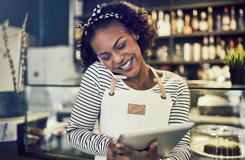 business-owner-talking-on-phone-while-on-tablet